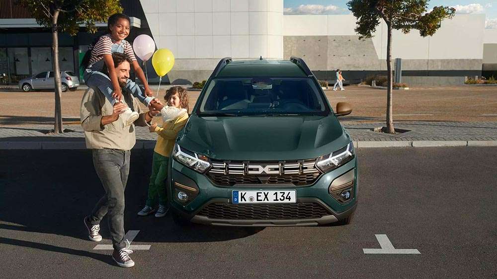 Dacia Jogger auf Parkfläche mit Familie