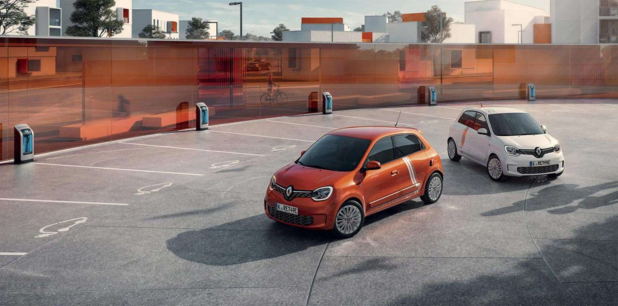 Zwei Renault Twingo auf einer Parkfläche umgeben von modernen Wohnhäusern