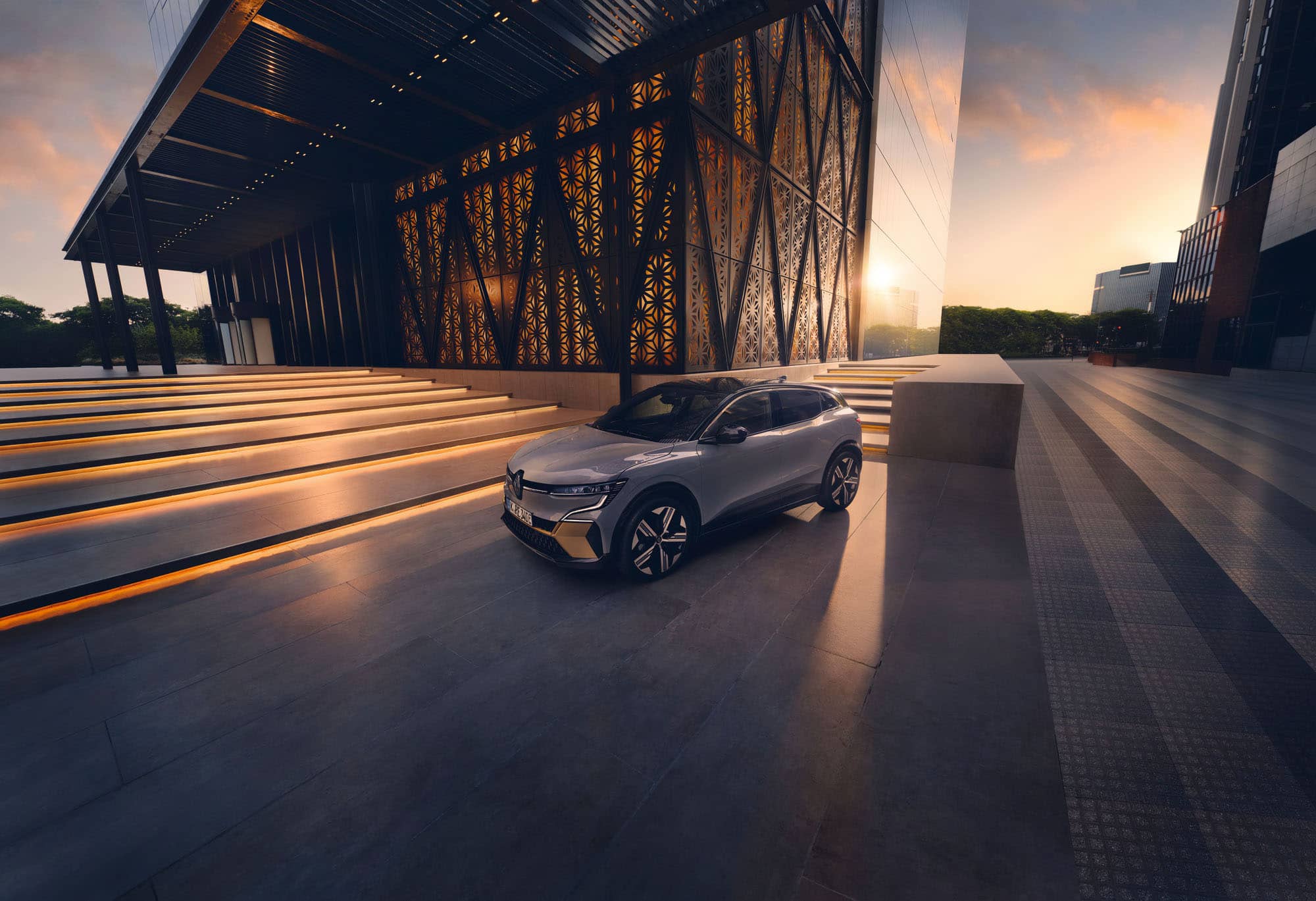 Renault Megane in der Mitte eines Platzes vor einem haus bei Sonnenuntergang