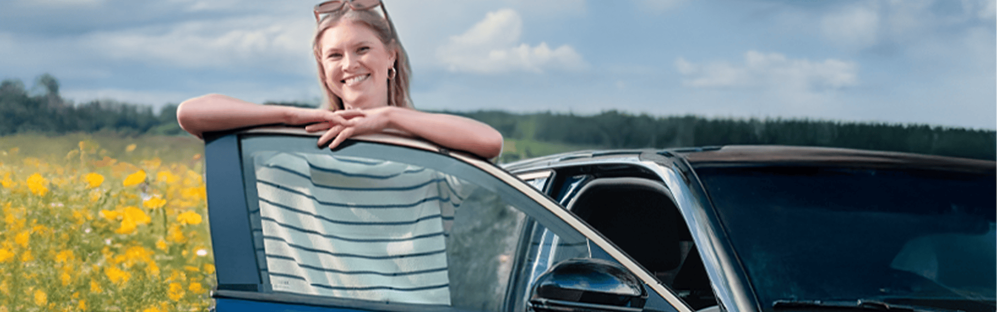 junge Frau neben Ihrem R5 vor einem Rapsfeld