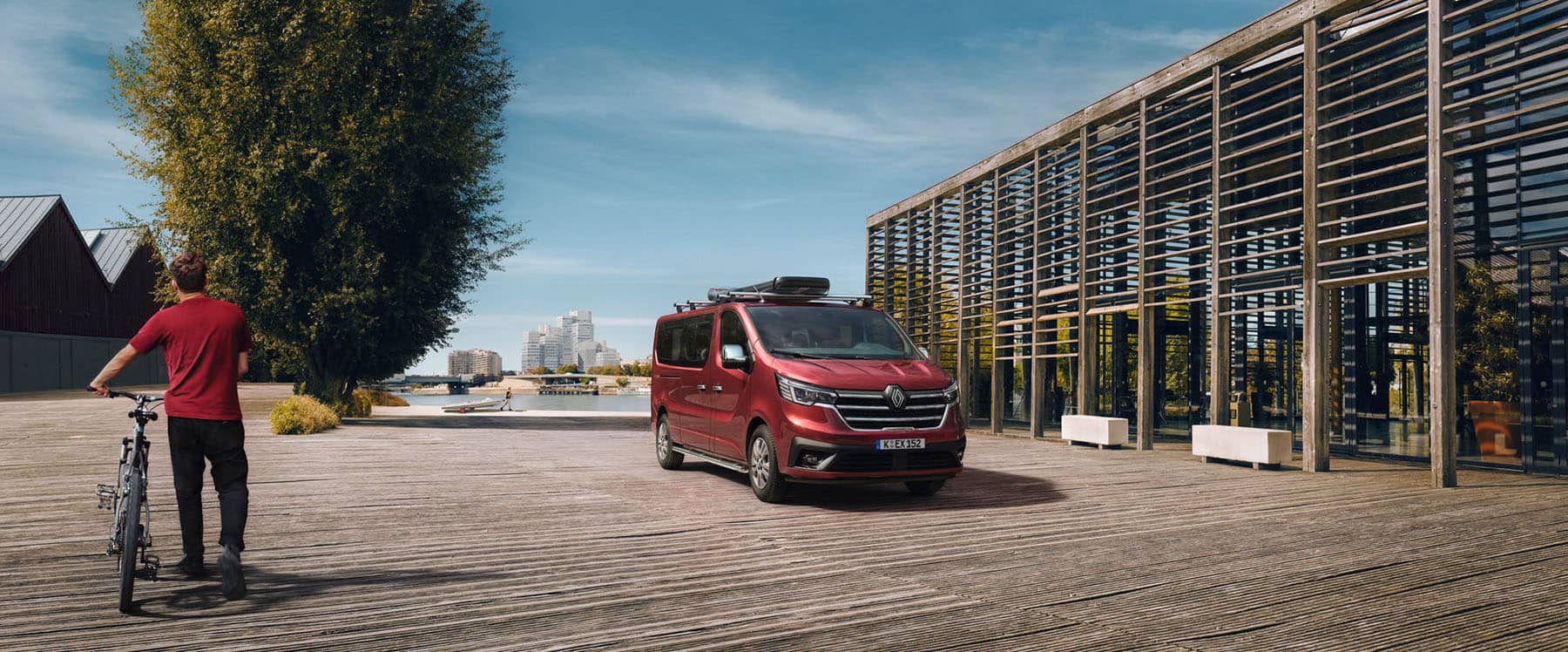 Renault Trafic Combi auf Parkplatz vor einem städtischen Fluss