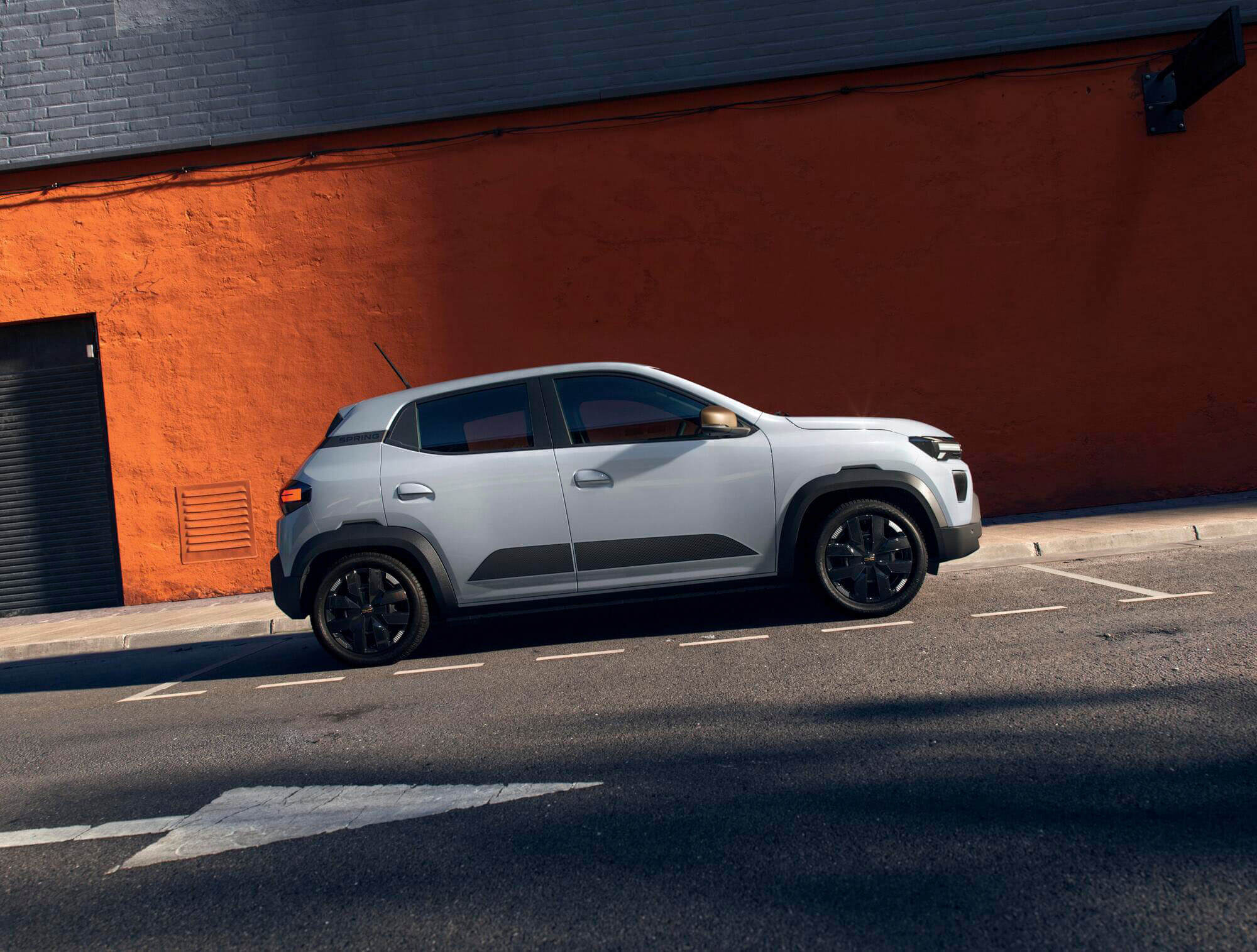 Dacia Spring Facelift in der Profilansicht auf einer Straße