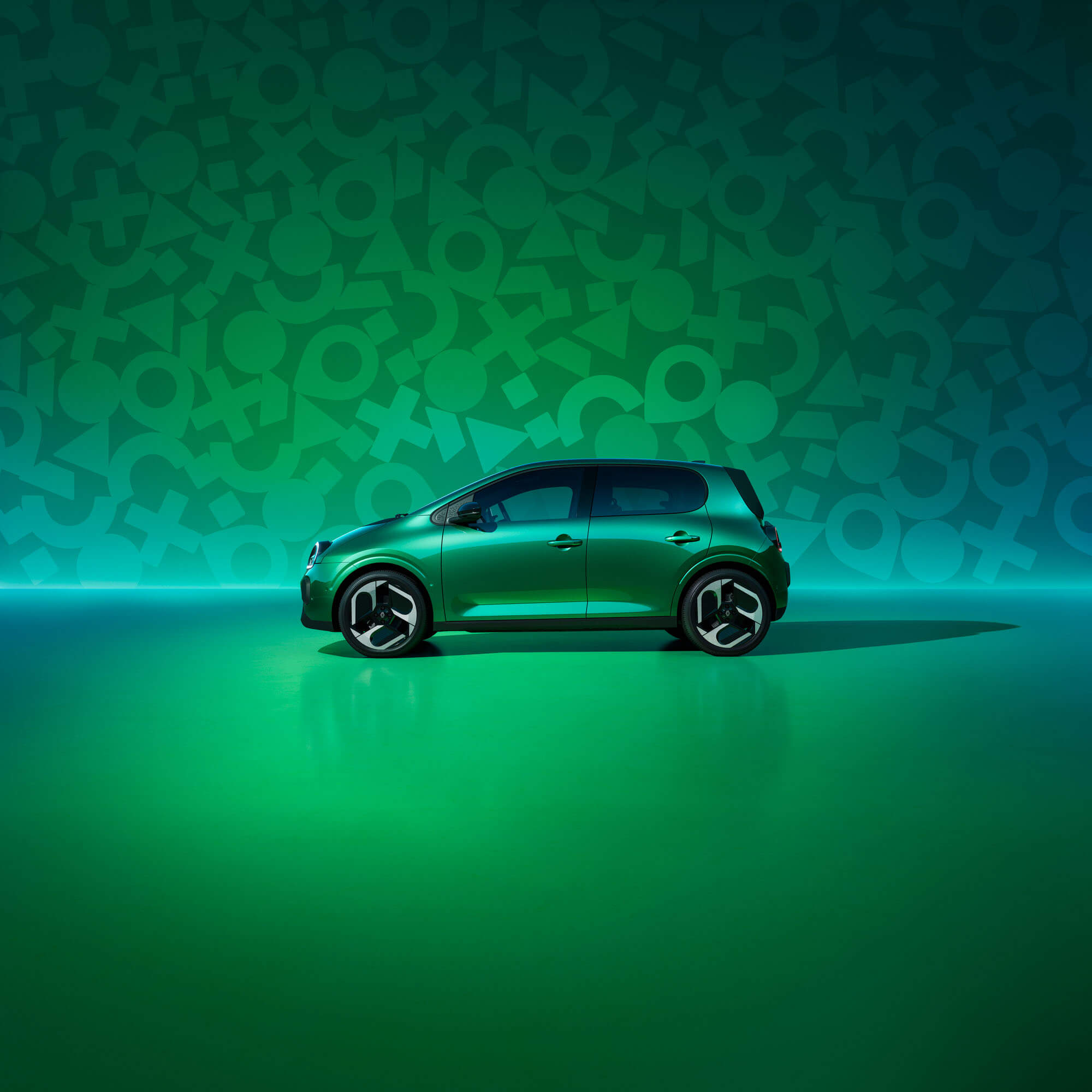 Renault Twingo im Profil vor grüner Wand mit Twingo Symbolen