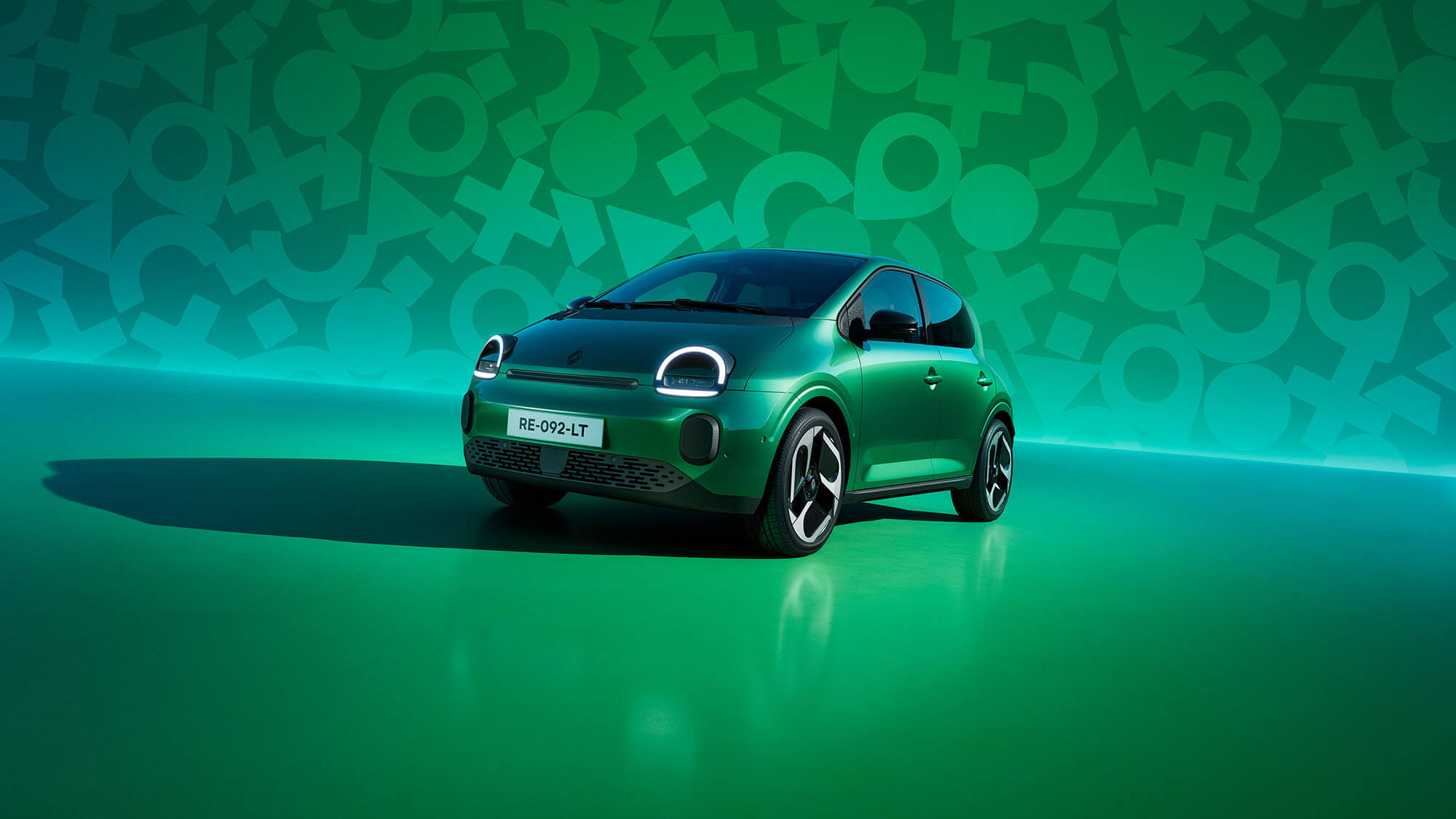 Renault Twingo in grün vor einer grünen Wand mit Twingo Symbolen