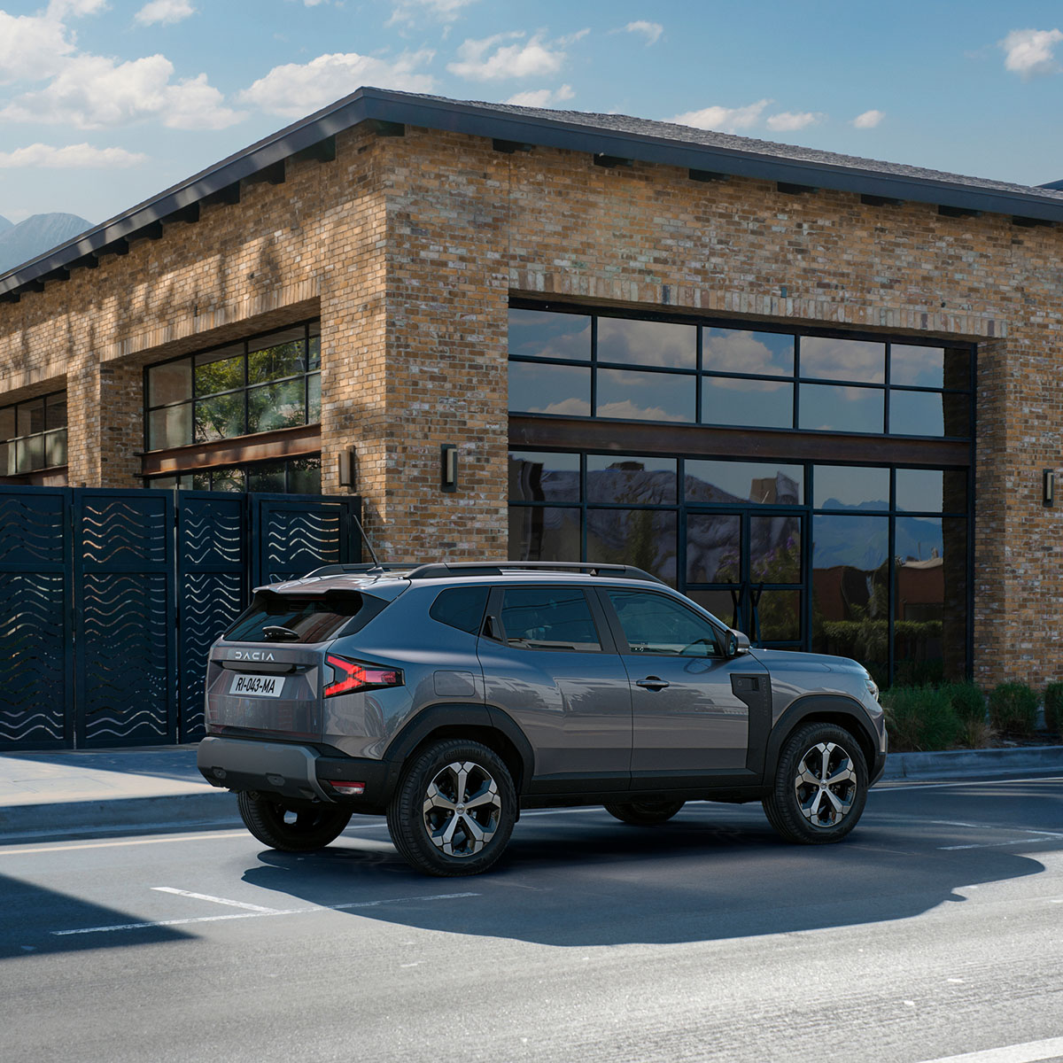 Dacia Duster in silber vor einer Hauseinfahrt
