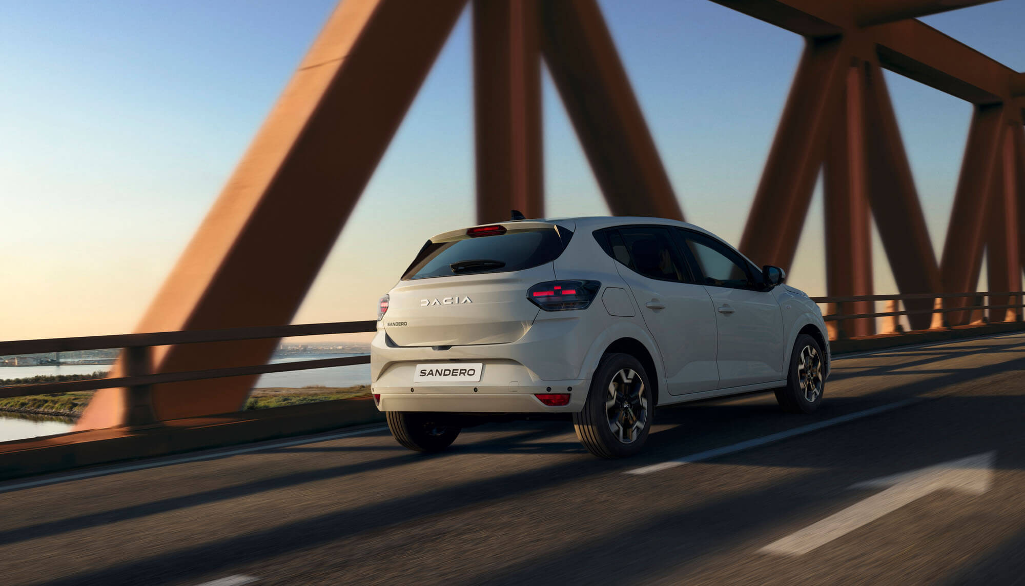 Dacia Sandero fahrend auf einer Brücke Rückansicht